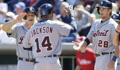 Detroit Tigers' Austin Jackson, center, celebrates with teammates Andy Dirks, left, and Jordan Lennerton, right, after the three players scored on a double by teammate Nick Castellanos during the first inning of an exhibition baseball game against the Detroit Tigers Friday, Feb. 28, 2014, in Clearwater, Fla. (AP Photo/Charlie Neibergall)