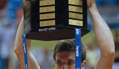 Argentina's Federico Delbonis holds up his Brazil Open ATP tennis tournament trophy after defeating Italy's Paolo Lorenzi in the final match in Sao Paulo, Brazil, Sunday, March 2, 2014. (AP Photo/Andre Penner)