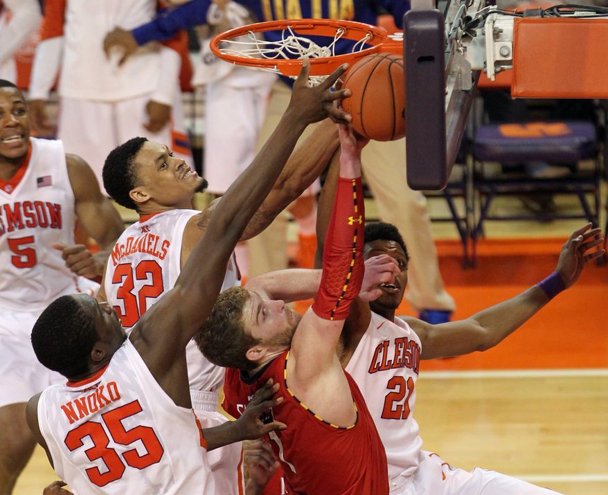 Clemson's Landry Nnoko (35), K.J. McDaniels (32), Demarcus Harrison (21) and Maryland's Evan Smotrycz trap the ball against the glass as they battle for a rebound in the first overtime of their NCAA college basketball game, Sunday, March 2, 2014 in Clemson. S.C. Clemson won, 77-73 in double overtime. (AP Photo/Anderson Independent-Mail, Mark Crammer) GREENVILLE NEWS - OUT; SENECA JOURNAL - OUT