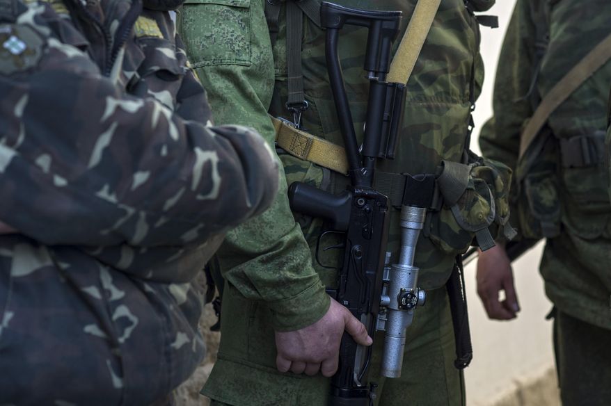 Unidentified gunmen stand outside entrance to the General Staff Headquarters of the Ukrainian Navy in Sevastopol, Ukraine, Monday, March 3, 2014. Pro-Russian soldiers seem to further cement their control over the strategic region, that also houses the Russian Black Sea Fleet, by seizing a ferry terminal in the Ukrainian city of Kerch about 20 kilometers (12 miles) by boat to Russia, intensifying fears that Moscow will send even more troops into the peninsula. (AP Photo/Andrew Lubimov)