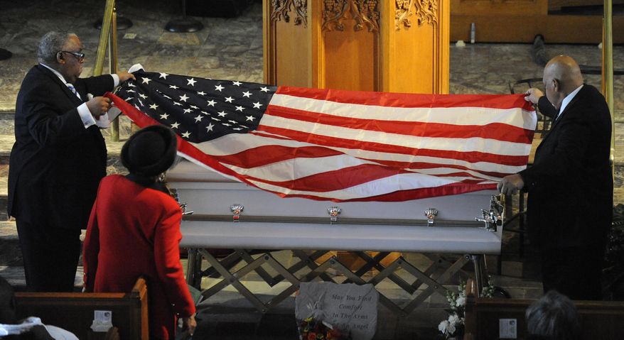 A flag is draped over the casket of Jayvon Felton during funeral services at Hartford Memorial Baptist Church in Detroit on Monday, March 3, 2014 in Detroit.  Chief James Craig spoke during the family hour ahead of the service and said the department wanted to treat Jayvon’s funeral as if the boy was an officer. Jayvon was in an open casket and wore a police badge.  Jayvon was diagnosed in April with leukemia. He died Feb. 24 at a Detroit hospital. The fourth-grader had always wanted to be a Detroit police officer. (AP Photo/Detroit News, David Coates)  DETROIT FREE PRESS OUT; HUFFINGTON POST OUT