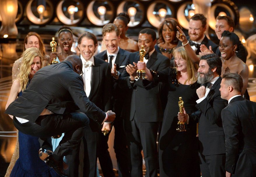 Director Steve McQueen, left, celebrates with the cast and crew of "12 Years a Slave" as they accept the award for best picture during the Oscars at the Dolby Theatre on Sunday, March 2, 2014, in Los Angeles. (Photo by John Shearer/Invision/AP)