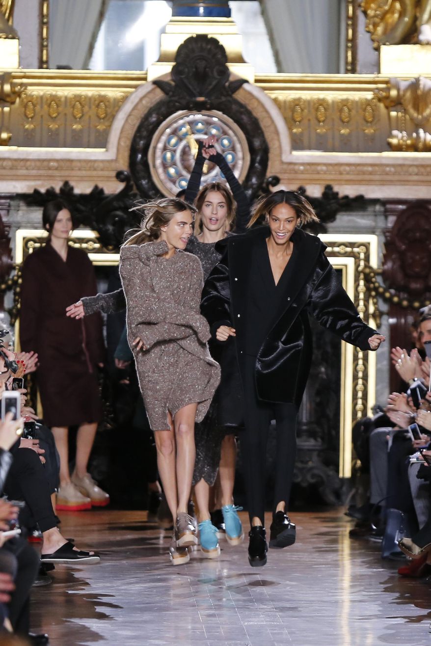 Models Cara Delevingne, left, and Joan Smalls dance during Stella McCartney&#39;s ready-to-wear fall/winter 2014-2015 fashion collection presented in Paris, Monday, March 3, 2014. (AP Photo/Jacques Brinon)