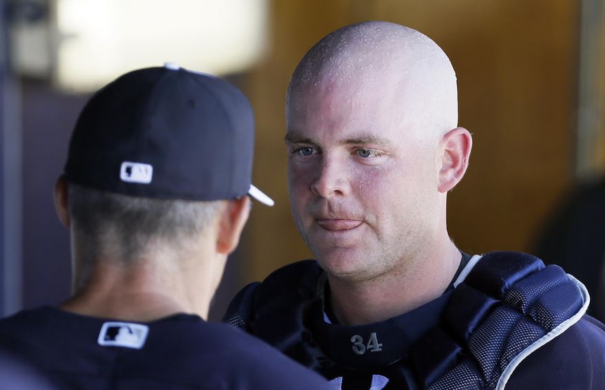 New York Yankees catcher Brian McCann, right, talks with manager Joe Girardi, left, during the second inning of an exhibition baseball game against the Washington Nationals, Monday, March 3, 2014, in Tampa, Fla. (AP Photo/Charlie Neibergall)