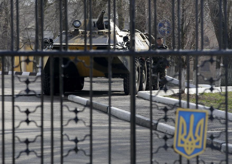 A Ukrainian armored personnel carrier is stationed behind the gate of a military base in the port of Kerch, Ukraine, Monday, March 3, 2014. Pro-Russian troops controlled a ferry terminal on the easternmost tip of Ukraine's Crimea region close to Russia on Monday, intensifying fears that Moscow will send even more troops into the strategic Black Sea region in its tense dispute with its Slavic neighbor. (AP Photo/Darko Vojinovic)