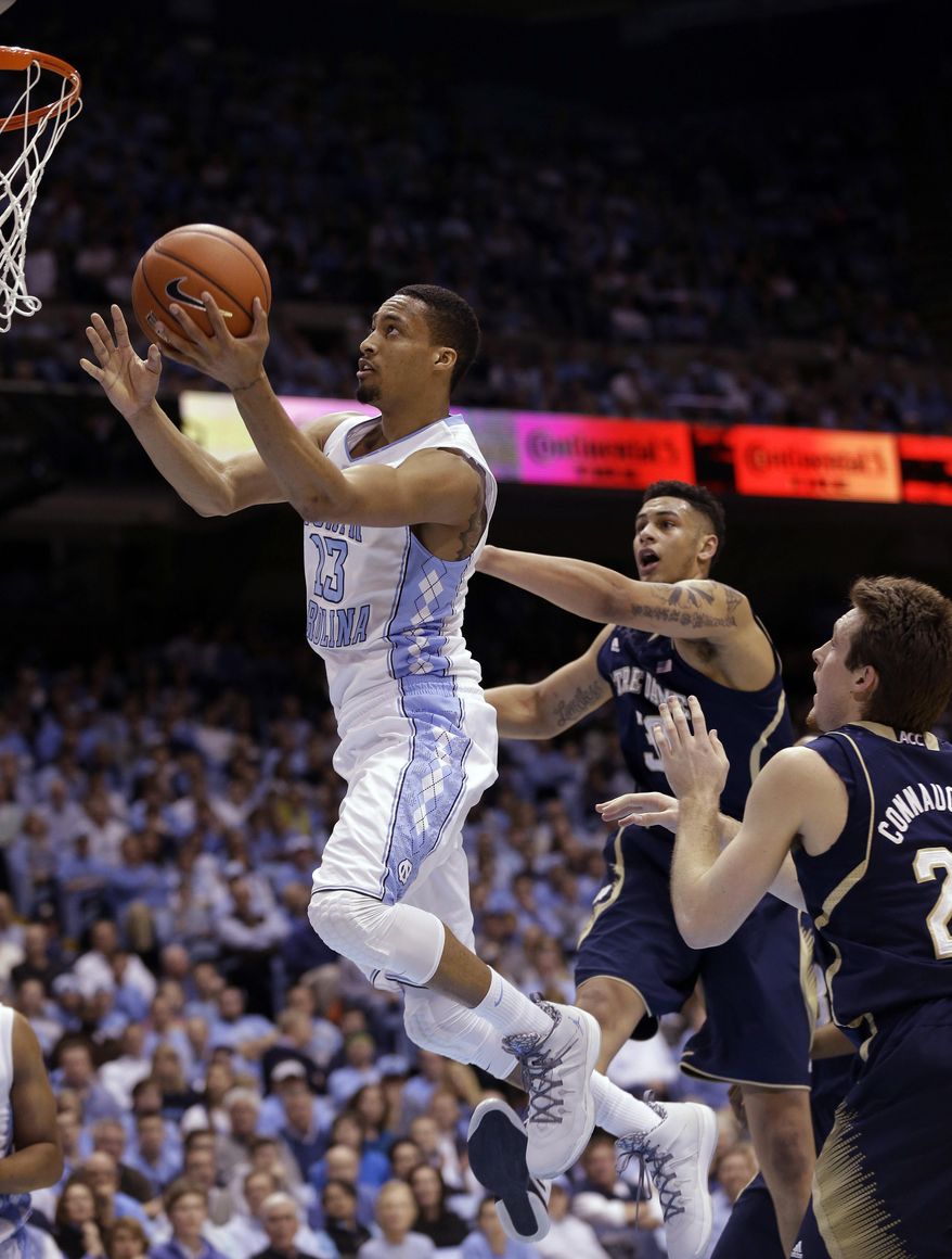 North Carolina's J.P. Tokoto (13) drives to the basket as Notre Dame's Zach Auguste and Pat Connaughton, right, defend during the first half of an NCAA college basketball game in Chapel Hill, N.C., Monday, March 3, 2014. (AP Photo/Gerry Broome)