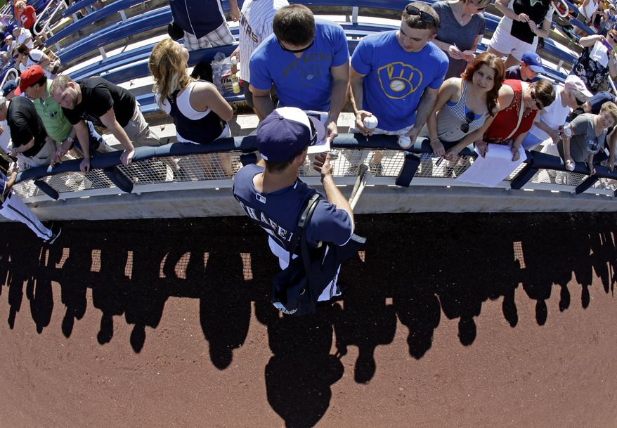 Milwaukee Brewers' Logan Schafer signs autographs before an exhibition spring training baseball game against the Chicago Cubs Monday, March 3, 2014, in Phoenix. (AP Photo/Morry Gash)