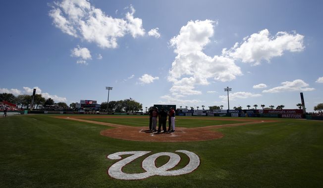 Managers from both teams meet with the umpires at the plate before a spring exhibition baseball game between the Atlanta Braves and the Washington Nationals at Space Coast Stadium, Saturday, March 1, 2014, in Viera, Fla. (AP Photo/Alex Brandon)