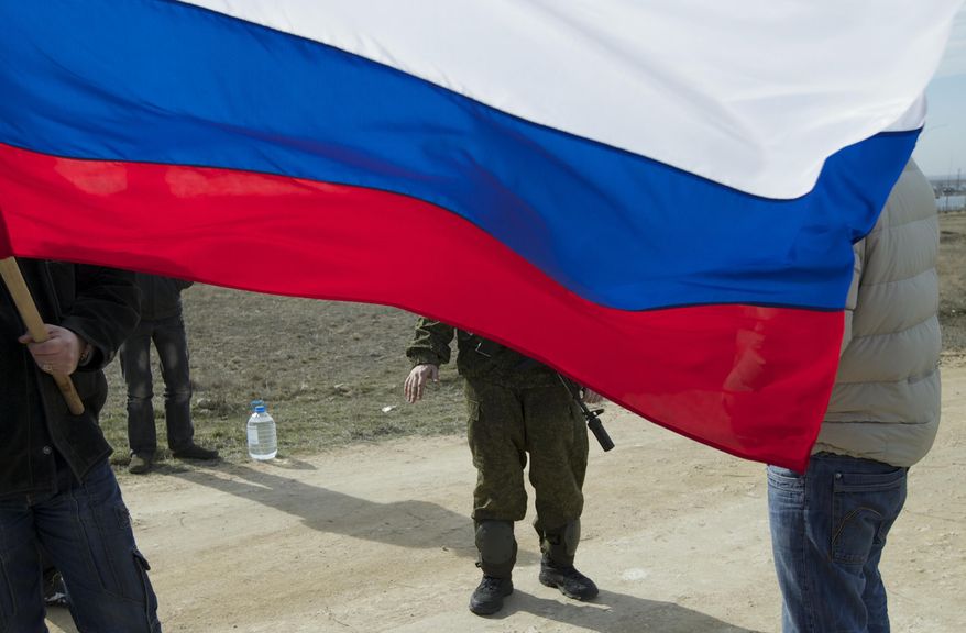 A Russian soldier talks to local residents as he and comrades block the Ukrainian naval base in the town of Novo-Ozerne, some 90 km west of the Crimean capital Simferopol, Ukraine, on Monday, March 3, 2014. For years, the little Crimean town was closed off from the rest of the world, a secretive community, at the edge of a key Soviet naval base, sealed by roadblocks and armed guards. There’s not much in town anymore. But the Russians want it. And the little forgotten town is now sharply divided, torn between those who welcomed the arrival here over the weekend of dozens of Russian soldiers wearing unmarked uniforms, and those who back the Ukrainians who are refusing to surrender their weapons. (AP Photo/Ivan Sekretarev)