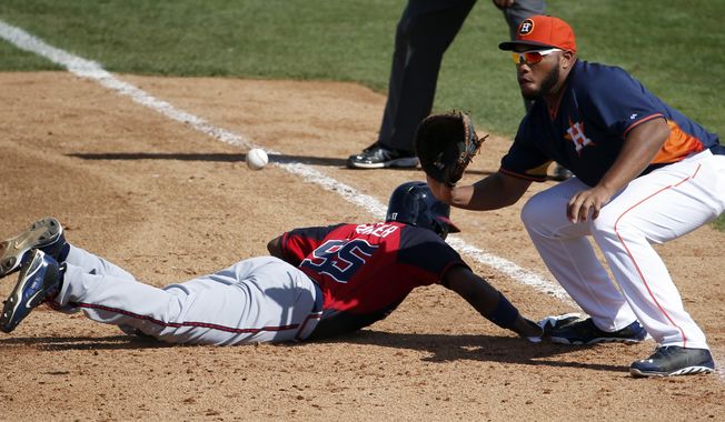 Atlanta Braves&#x27; Cedric Hunter, left, gets back to first in time as Houston Astros first baseman Jon Singleton waits for the ball in the sixth inning of a spring exhibition baseball game on Sunday, March 2, 2014, in Kissimmee, Fla. The Astros won 7-4. (AP Photo/Alex Brandon)