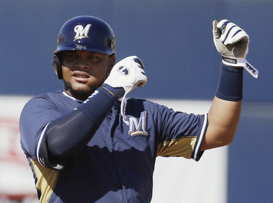 Milwaukee Brewers' Juan Francisco points to his muscle after hitting an RBI double during the fourth inning of an exhibition spring training baseball game against the Chicago Cubs, Monday, March 3, 2014, in Phoenix. (AP Photo/Morry Gash)