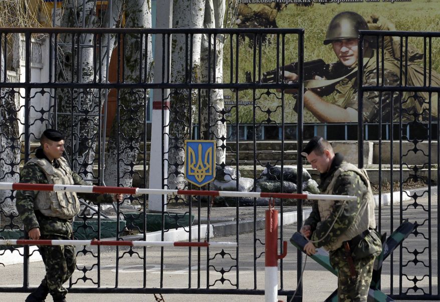 Ukrainian soldiers stand guard at the gate of a military base in the port of Kerch, Ukraine, Monday, March 3, 2014. Pro-Russian troops controlled a ferry terminal on the easternmost tip of Ukraine's Crimea region close to Russia on Monday, intensifying fears that Moscow will send even more troops into the strategic Black Sea region in its tense dispute with its Slavic neighbor. (AP Photo/Darko Vojinovic)