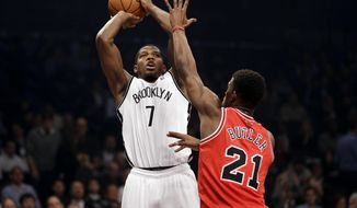Brooklyn Nets&#x27; Joe Johnson, left, shoots over Chicago Bulls&#x27; Jimmy Butler during the first half of an NBA basketball game Monday, March 3, 2014, in New York. (AP Photo/Seth Wenig)