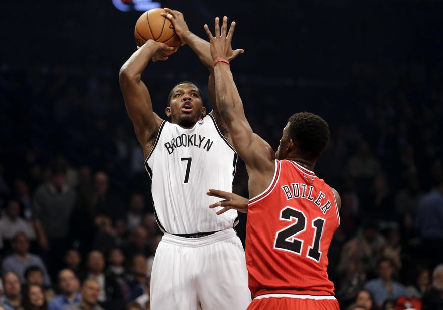 Brooklyn Nets' Joe Johnson, left, shoots over Chicago Bulls' Jimmy Butler during the first half of an NBA basketball game Monday, March 3, 2014, in New York. (AP Photo/Seth Wenig)