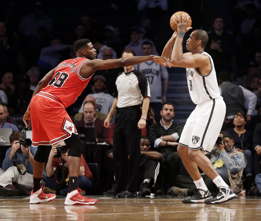 Brooklyn Nets' Jason Collins, right, takes a shot over Chicago Bulls' Nazr Mohammed during the second half of an NBA basketball game Monday, March 3, 2014, in New York. The Nets won 96-80. (AP Photo/Seth Wenig)