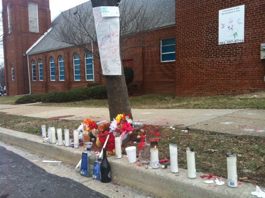 A makeshift memorial marks the spot where two brothers, 26-year-old Jason Bryant and 34-year-old Khalid Bryant, were gunned down Friday night outside a church in Northeast D.C. (Andrea Noble/The Washington Times)