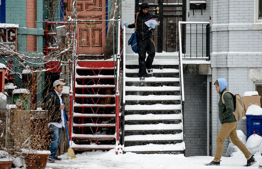 JosŽ Rosado, left, sweeps snow from the stairs of Thai X-ing in Shaw as the region gets 6-8 inches of snow, Washington, D.C., Monday, March 3, 2014. (Andrew Harnik/The Washington Times)