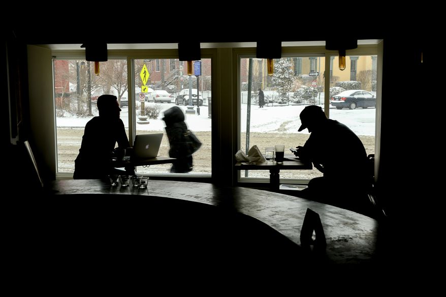 Craig Kujawa, left, and Steve Guilday, right, sit in Bistro Bohem as the region gets 6-8 inches of snow, Washington, D.C., Monday, March 3, 2014. (Andrew Harnik/The Washington Times)