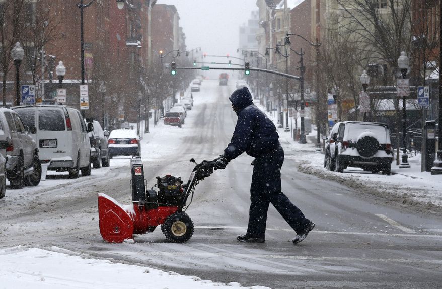 A man pushes a snow blower across a street as a light snow falls in Baltimore, Monday, March 3, 2014. Winter kept its icy hold on much of the country Monday, with snow falling and temperatures dropping as schools and offices closed and people from the Mid-Atlantic to Northeast reluctantly waited out another storm indoors. (AP Photo/Patrick Semansky)
