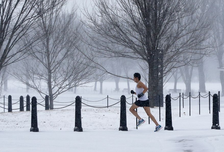 An unidentified man braves the elements as he runs on the National Mall as snow falls in Washington, Monday, March 3, 2014. The National Weather Service has issued a Winter Storm Warning for the greater Washington Metropolitan region, prompting area schools and the federal government to close for the wintry weather. (AP Photo/Charles Dharapak)