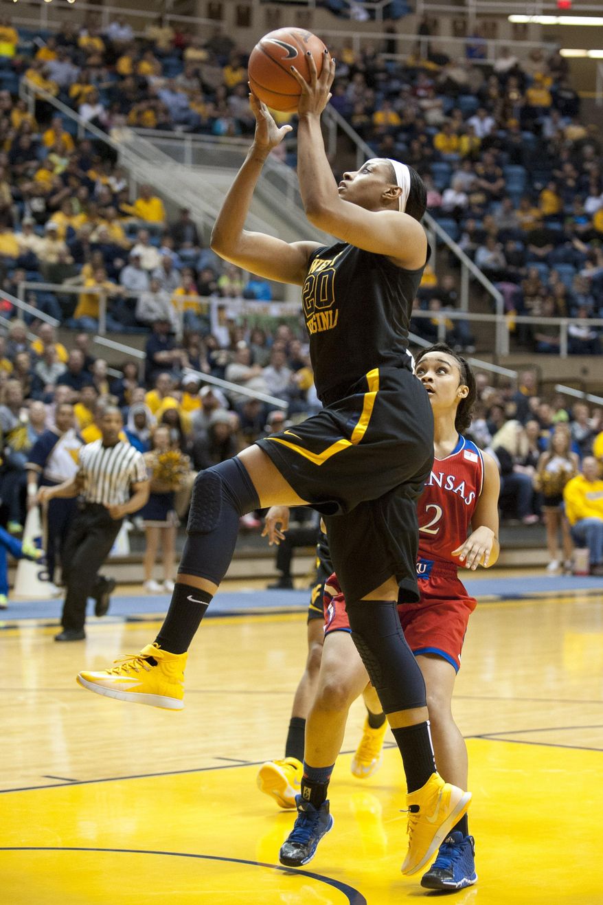 West Virginia's Asya Bussie (20) drives to the basket during the first half of an NCAA college basketball game against Kansas, Tuesday, March 4, 2014, in Morgantown, W.Va. (AP Photo/Andrew Ferguson)