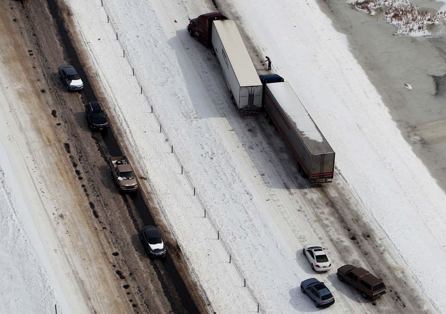 Two semitrailers block traffic after colliding in North-bound Interstate 55 near Turrell, Ark., Tuesday, March 4, 2014. Some motorists on the highway in eastern Arkansas were stranded overnight due to lingering icy conditions from a weekend winter storm. An Arkansas highway department spokesman said Tuesday that traffic can't get moving consistently because of repeated accidents. (AP Photo/The Commercial Appeal, Mike Brown)