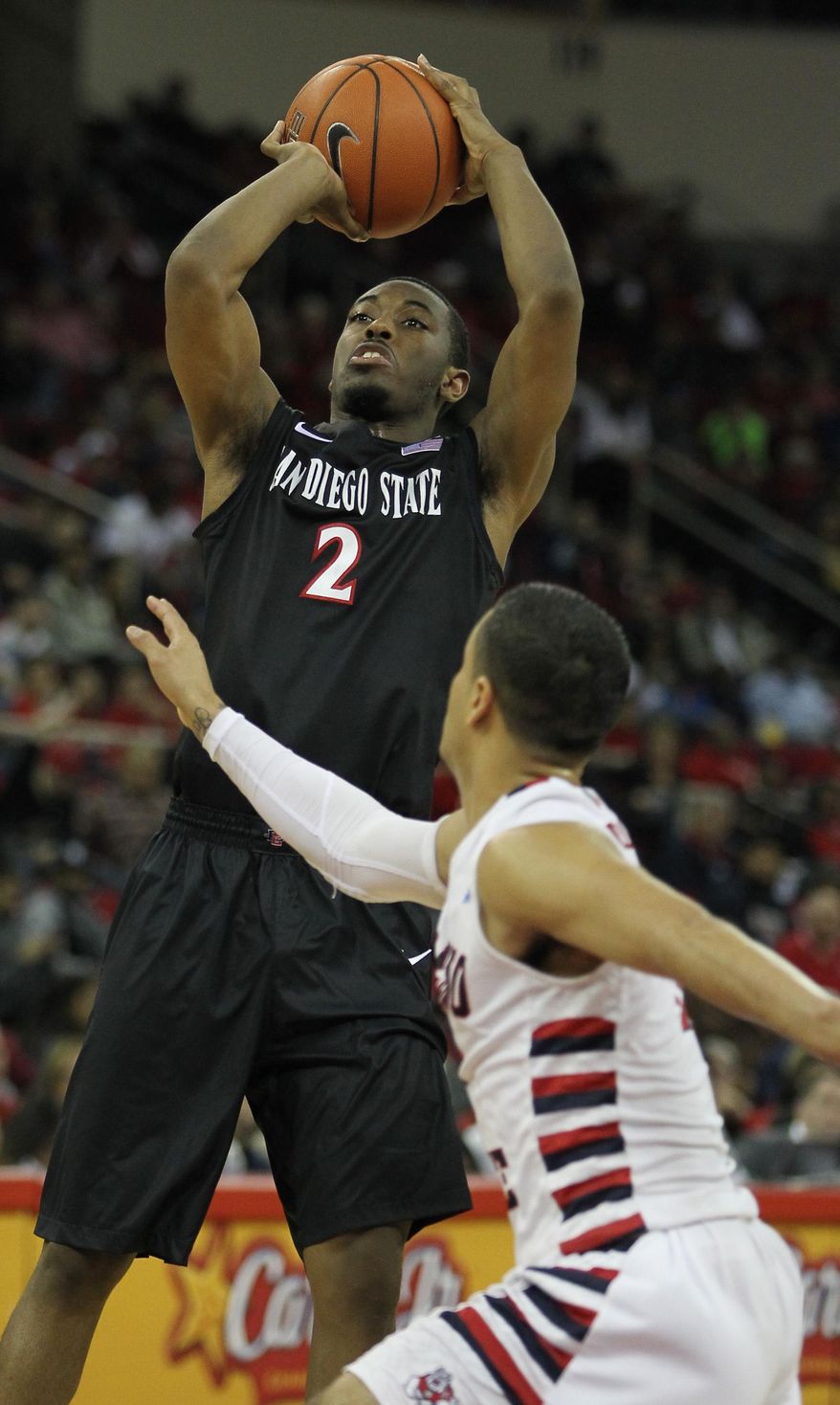San Diego State's Xavier Thames scores 2 of his game high 22 points against Fresno State's Cezar Guerrero for the ball in the second half of an NCAA college basketball game in Fresno, Calif., Saturday, March 1, 2014. (AP Photo/Gary Kazanjian)