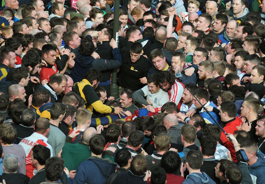 Players compete for the ball during the Royal Shrovetide Football match in Ashbourne, Derbyshire England Tuesday, March 4, 2014 . The Royal Shorvetide Football match occurs annually on Shrove Tuesday and Ash Wednesday in the town of Ashbourne, where it has been played since at least the 12th Century. The game, which pits the two sides of Ashbourne against each other, has only around six rules some of which are players are not allowed to commit murder or manslaughter; and the ball cannot be carried in a motorised vehicle or be hidden in a bag. (AP Photo/Rui Vieira)