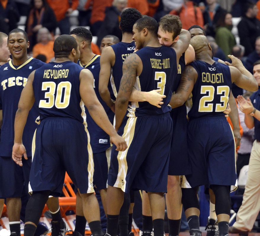 Georgia Tech players celebrate after defeating Syracuse 67-62 in an NCAA college basketball game in Syracuse, N.Y., Tuesday, March 4, 2014. (AP Photo/Kevin Rivoli)