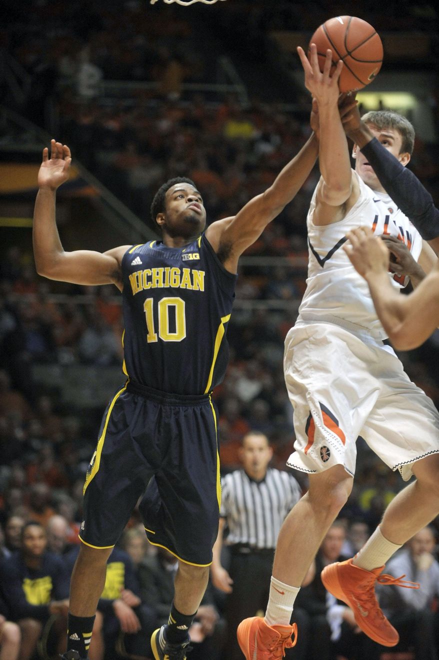 Michigan guard Derrick Walton Jr. (10) and Illinois forward Jon Ekey (33) vie for a rebound during the first half of an NCAA college basketball game Tuesday, March 4, 2014, in Champaign, Ill. (AP Photo/Rick Danzl)