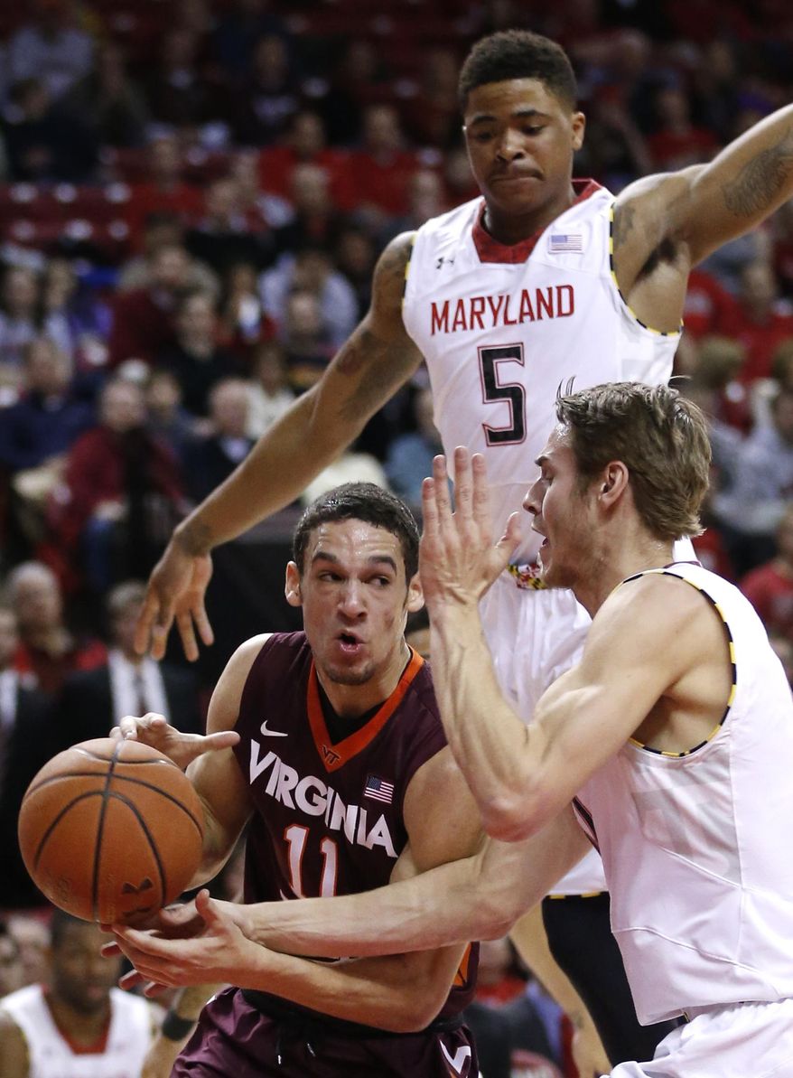 Virginia Tech guard Devin Wilson, bottom left, is pressured by Maryland guards Nick Faust (5) and Jake Layman as he drives to the basket during the first half of an NCAA college basketball game in College Park, Md., Tuesday, March 4, 2014. (AP Photo/Patrick Semansky)