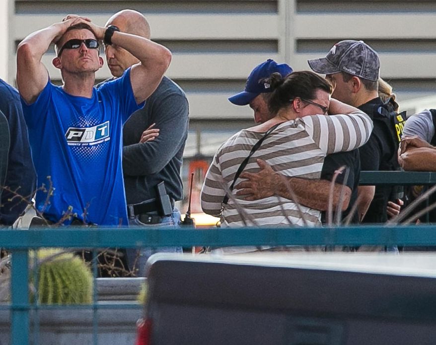 Police officers, public safety officials, friends and family react to an update at St. Joseph's Hospital on Monday, March 3, 2014, in Phoenix, about the police-involved shooting that took place Monday afternoon in Phoenix. A Phoenix police officer died and another was in critical condition after a shootout Monday that also killed a man wanted on a felony warrant, authorities said. (AP Photo/The Arizona Republic, Michael Schennum)