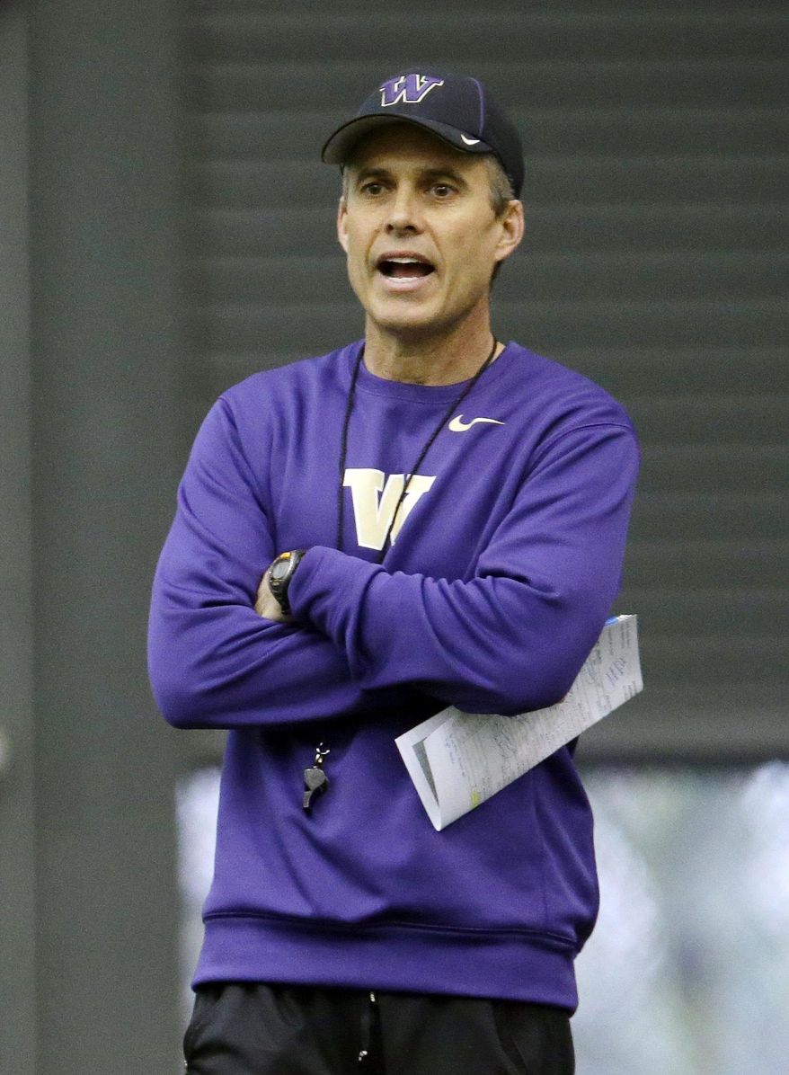 New Washington head football coach Chris Petersen calls to his team on the first day of spring NCAA college football practice, Tuesday, March 4, 2014, in Seattle. (AP Photo/Ted S. Warren)