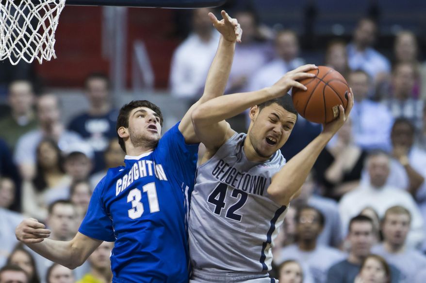 Georgetown center Bradley Hayes (42) pulls down a rebound over Creighton center Will Artino (31) during the first half of an NCAA basketball game on Tuesday, March 4, 2014, in Washington. (AP Photo/ Evan Vucci)