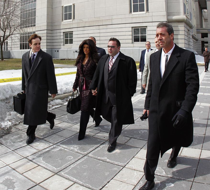 Teresa, center, left, and Joe Giudice, center right, from “The Real Housewives of New Jersey,” leave federal court in Newark, N.J. on Tuesday, March 4, 2014. They each pleaded guilty to several counts including bankruptcy fraud, conspiracy to commit mail fraud and wire fraud, and failing to pay taxes. (AP Photo/Rich Schultz)