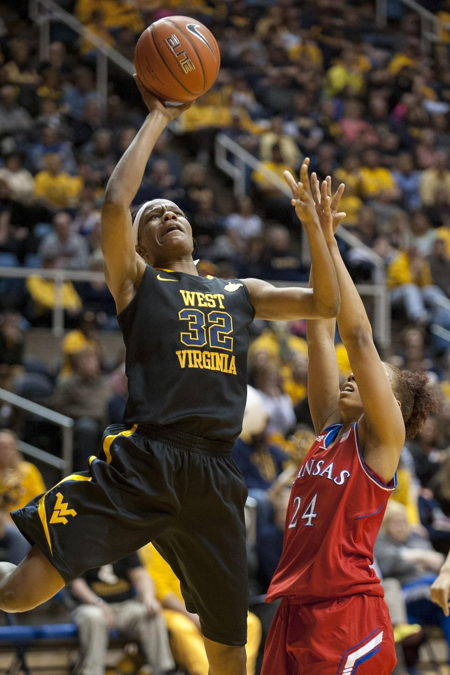 West Virginia's Crystal Leary, left, looks to shoot over Kansas' CeCe Harper during the first half of an NCAA college basketball game Tuesday, March 4, 2014, in Morgantown, W.Va. (AP Photo/Andrew Ferguson)