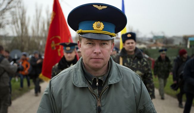 Col. Yuri Mamchur, commander of the Ukrainian garrison at the Belbek air base, lead his men to the base outside Sevastopol, Ukraine, Tuesday, March 4, 2014. Russian troops, who had taken control over Belbek airbase, fired warning shots in the air as around 300 Ukrainian officers marched towards them to demand their jobs back. (AP Photo/Ivan Sekretarev)