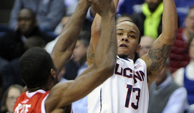 Connecticut&#x27;s Shabazz Napier (13) shoots over Rutgers&#x27; Malick Kone during the first half of an NCAA college basketball game in Storrs, Conn., Wednesday, March 5, 2014. (AP Photo/Fred Beckham)