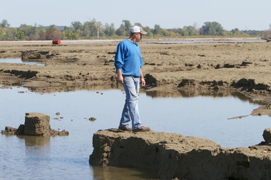 In this photo from Sept. 19, 2011, Rob Chatt surveys damage from the Missouri River flooding to his family farm in Tekamah, Neb. A group of farmers and business owners sued the U.S. Army Corps of Engineers on Wednesday, March 5, 2014, seeking compensation for claims the agency mismanaged the Missouri River since 2006 and contributed to major flooding in five states. The federal lawsuit claims some plaintiffs experienced extensive damage, particularly during the extended 2011 flooding that devastated hundreds of thousands of acres of mostly farmland in South Dakota, Nebraska, Iowa, Kansas and Missouri. (AP Photo/Nati Harnik)
