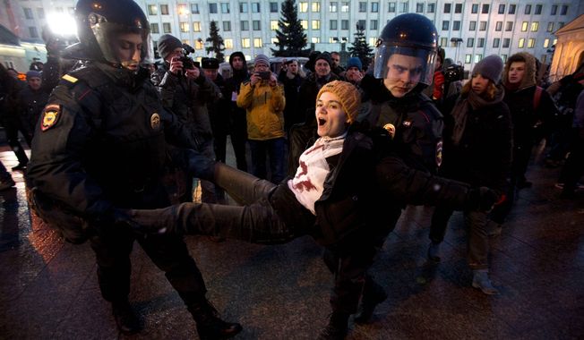 Police detain an activist outside the Russian Ministry of Defense building in Moscow during a unsanctioned demonstration against recent action in Ukraine. Several high-profile Russian figures, from national celebrities to much-loved writers, already have made clear their opposition to any war with fellow Slavs in Ukraine. (Associated Press)