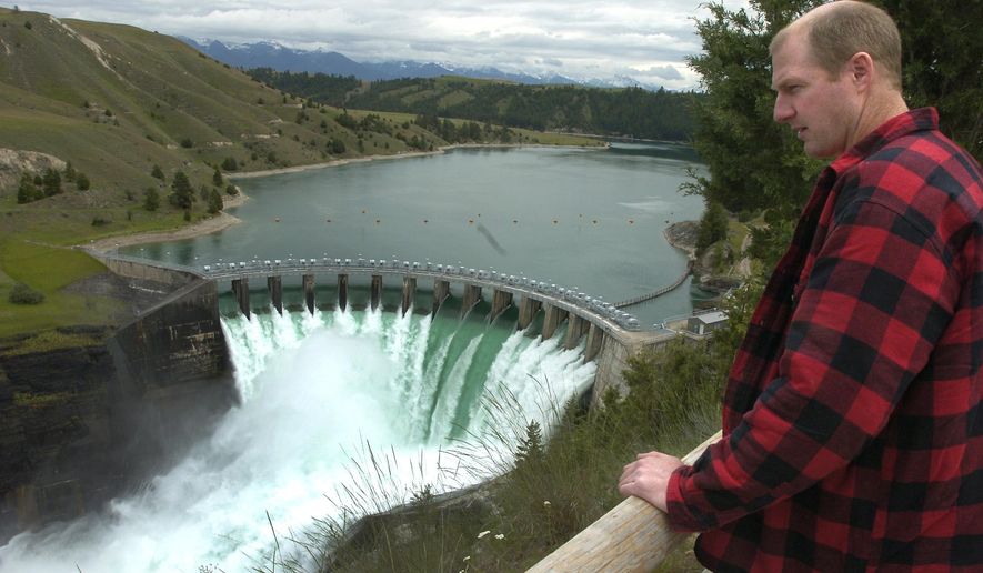 FILE - This June 8, 2005 file photo shows Terry McAllister, of Bigfork, Mont., checking out the Kerr Dam, near Polson, Mont. The Salish and Kootenai Tribes would have to pay nearly $18.3 million to acquire the northwestern Montana hydroelectric dam from PPL Montana, an arbitration panel has determined. Energy Keepers Inc., a tribally-owned corporation, said Wednesday, March 5, 2014 the tribes will notify the Federal Energy Regulatory Commission of their intent to acquire the Kerr Project on the Flathead River southwest of Polson in September 2015. (AP Photo/Daily Inter Lake, Chris Jordan, File)