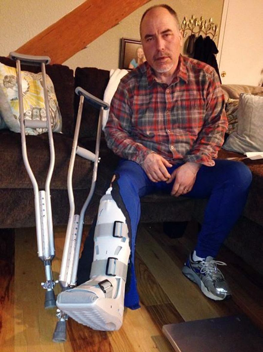 In this image provided by Chelsea Janssen, musher Scott Janssen poses for a photo showing his broken ankle on Wednesday, March 5, 2014 in Anchorage, Alaska. Janssen was flown to a hospital after a harrowing ordeal that included crashing his sled, hitting his head on a stump and later falling through ice and breaking his ankle during the Iditarod Trail Sled Dog Race.  Janssen, an Anchorage undertaker known as the Mushing Mortician, was back home early Wednesday after getting a cast for the broken bone he suffered on Tin Creek, about 40 miles from Nikolai, Alaska. (AP Photo/Chelsea Janssen)