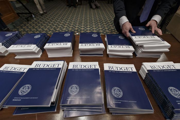Copies of President Barack Obama’s proposed fiscal 2015 budget are set out for distribution by Senate Budget Committee Clerk Adam Kamp, on Capitol Hill in Washington, Tuesday, March 4, 2014.  President Barack Obama is unwrapping a nearly $4 trillion budget that gives Democrats an election-year playbook for fortifying the economy and bolstering Americans&#39; incomes. It also underscores how pressure has faded to launch bold, new attacks on federal deficits.   (AP Photo/J. Scott Applewhite)