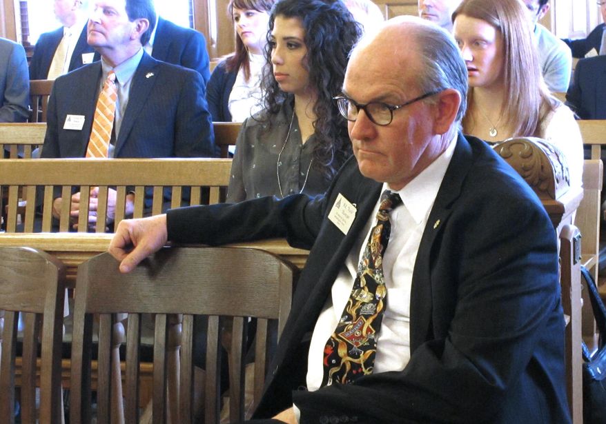 Tuck Duncan, lobbyist for the Kansas Wine and Spirits Wholesalers Association, watches a House committee hearing on liquor legislation, Wednesday, March 5, 2014, at the Statehouse in Topeka, Kan. The committee is reviewing proposals to ease restrictions on microbreweries and phase in sales of strong beer, wine and liquor in grocery and convenience stores. (AP Photo/John Hanna)