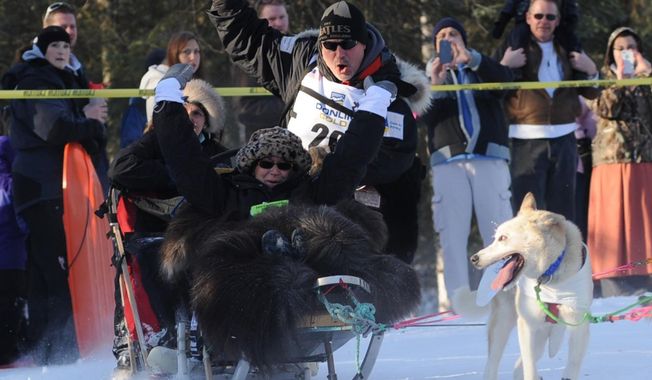 In a Saturday, March 1, 2014 photo, Scott Janssen keeps control of his sled rounding the corner near Goose Lake during the ceremonial start for Iditarod 42 in Anchorage, Ak. Janssen, an Anchorage undertaker known as the Mushing Mortician, was back home early Wednesday, Feb. 5 after he was flown to a hospital after a harrowing ordeal that included crashing his sled, hitting his head on a stump and later falling through ice and breaking his ankle. (AP Photo/Anchorage Daily News,Anne Raup)