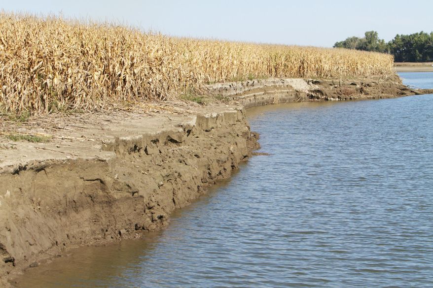 In this photo from Sept. 19, 2011, a pool of receding water left behind by the Missouri River flooding, reveals land erosion to a corn field near Takamah, Neb. A group of farmers and business owners sued the U.S. Army Corps of Engineers on Wednesday, March 5, 2014, seeking compensation for claims the agency mismanaged the Missouri River since 2006 and contributed to major flooding in five states. The federal lawsuit claims some plaintiffs experienced extensive damage, particularly during the extended 2011 flooding that devastated hundreds of thousands of acres of mostly farmland in South Dakota, Nebraska, Iowa, Kansas and Missouri. (AP Photo/Nati Harnik)