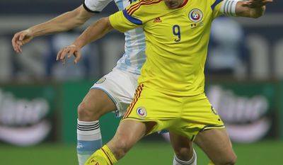 Argentina's Frederico Fernandez, left, challenges with Romania's Ciprian Marica, right, during an international friendly soccer game on the National Arena stadium in Bucharest, Romania, Wednesday, March 5, 2014. (AP Photo/Vadim Ghirda)