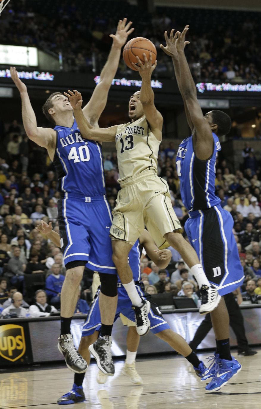 Wake Forest's Coron Williams, center, drives between Duke's Marshall Plumlee, left, and Amile Jefferson during the first half of an NCAA college basketball game in Winston-Salem, N.C., Wednesday, March 5, 2014. (AP Photo/Chuck Burton)