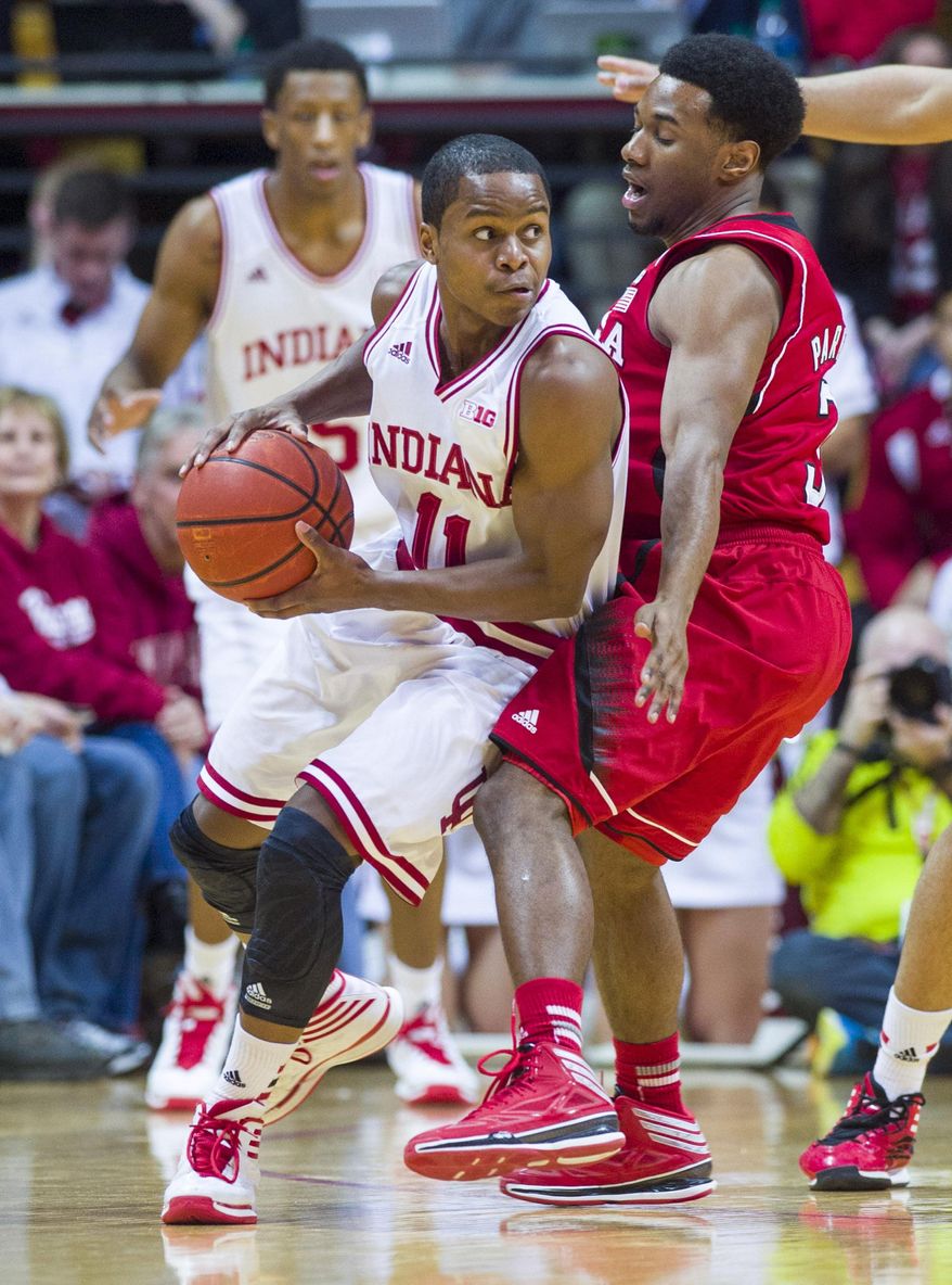 Indiana's Yogi Ferrell (11) drives the ball into the defense of Nebraska’s Shavon Shields (31) in the first half of an NCAA college basketball game, Wednesday, March 5, 2014, in Bloomington, Ind. (AP Photo/Doug McSchooler)
