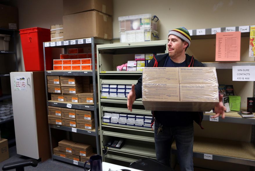 ADVANCE FOR USE MONDAY, MARCH 10 - In this photo taken on Thursday, Feb. 27, 2014, Brian Warden stocks syringes at the Minnesota AIDS Project needle exchange in Minneapolis, Minn. After years of running Minnesota's largest needle exchange, Warden is beginning to see something new among the increasing numbers of suburban and rural heroin users coming to trade in used needles. "What strikes me about it is they don't seem to have had what's traditionally called the gateway effect," Warden said. (AP Photo/Minnesota Public Radio, Jeffrey Thompson)